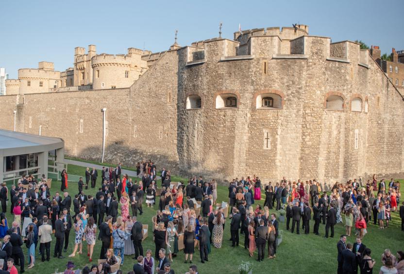 Large group in cocktail attire by the Tower of London at the 2019 summer party